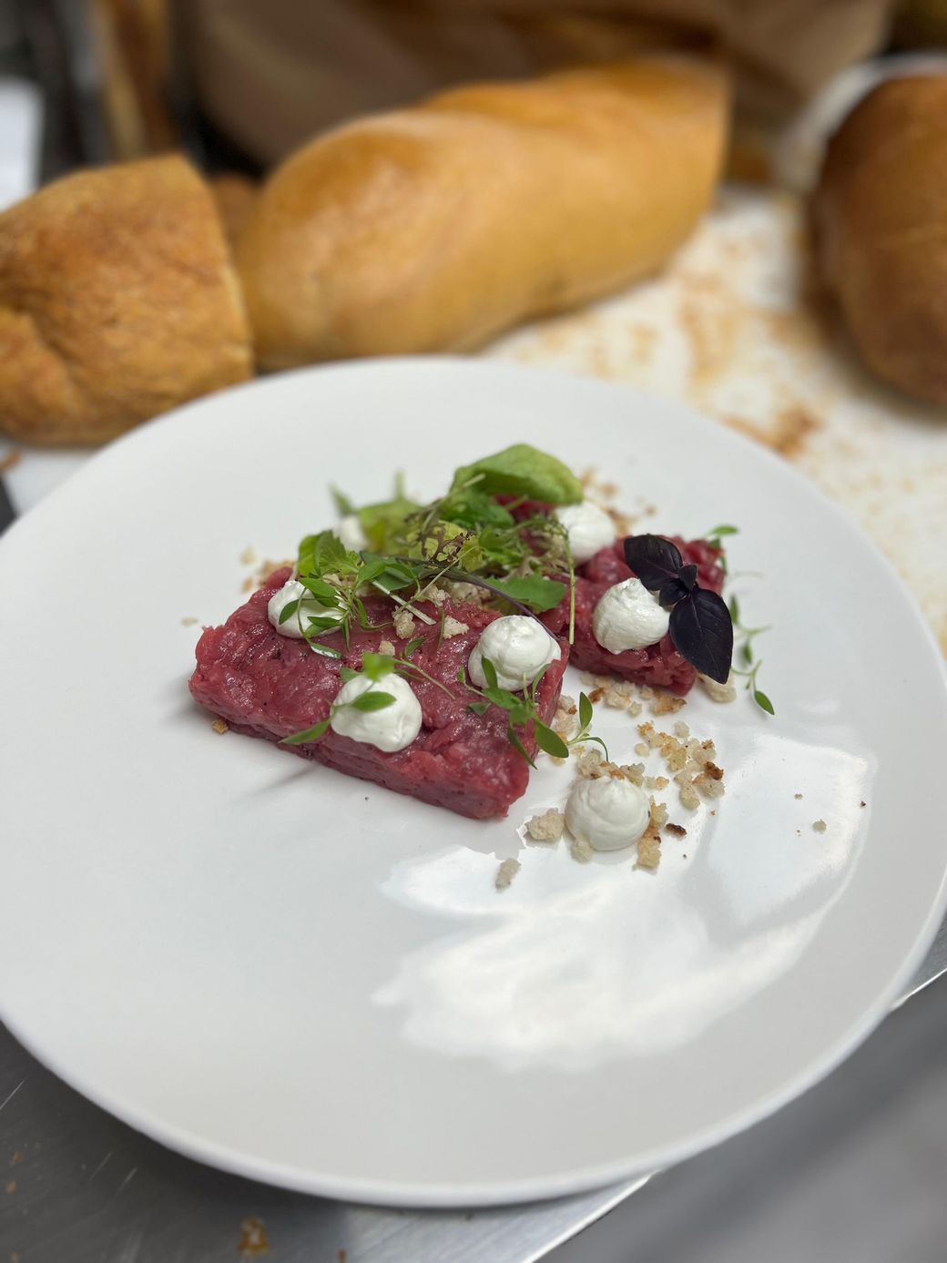 Un piatto bianco con sopra un pezzo di carne e formaggio.