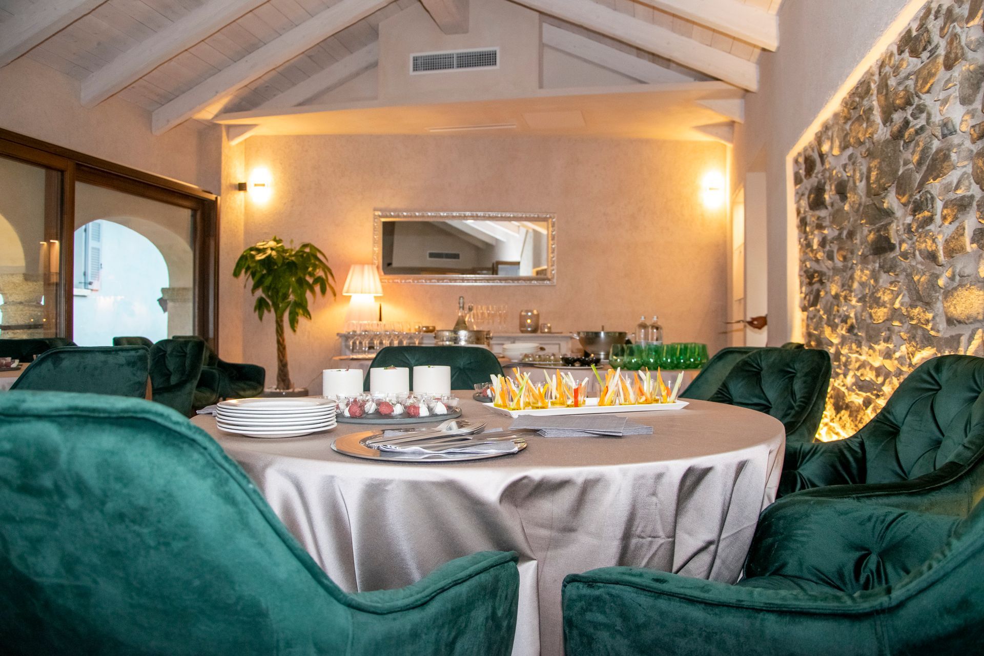 Un tavolo con una tovaglia bianca e sedie verdi in una stanza.