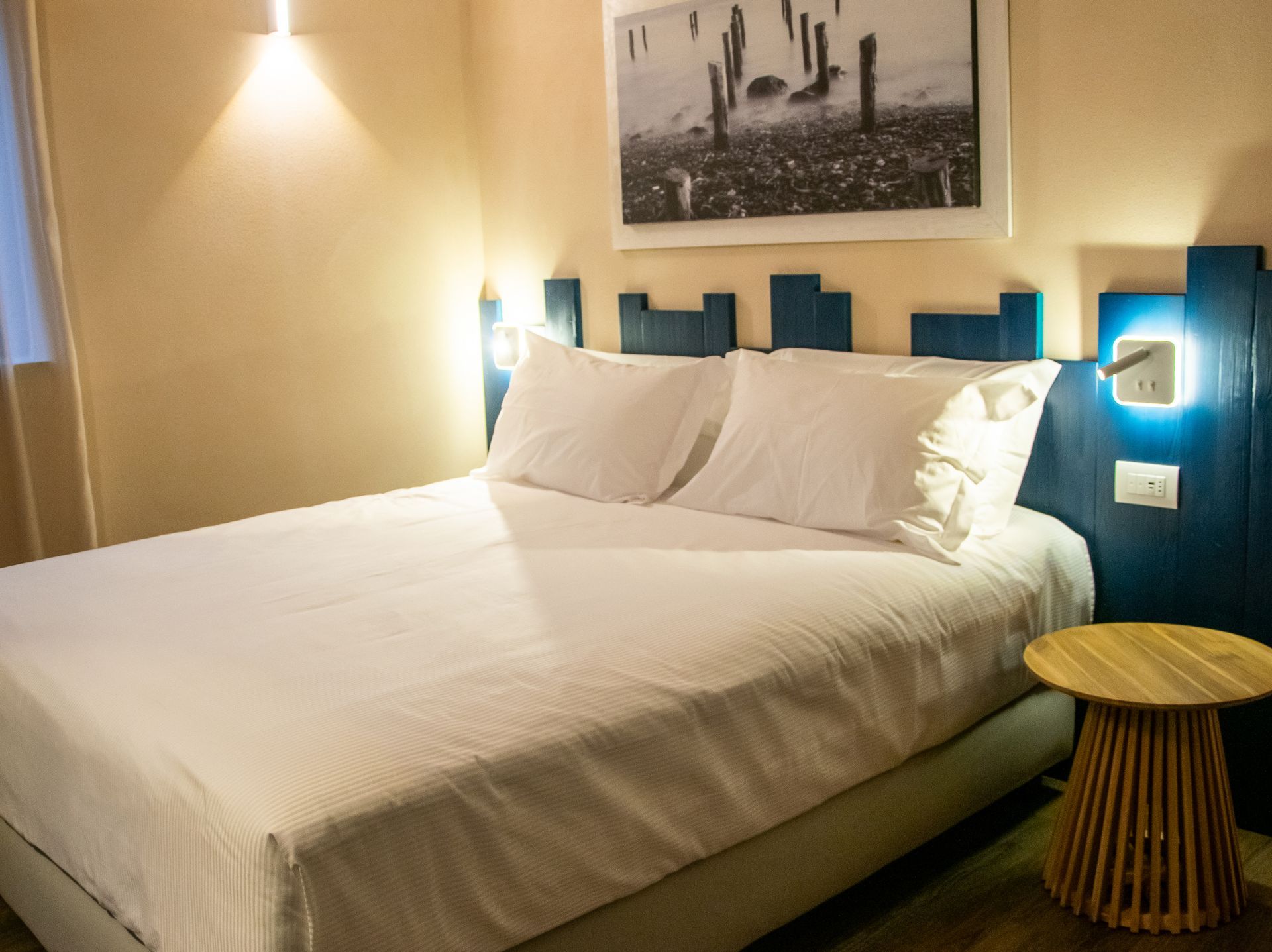 Una camera d'albergo con un letto grande e un tavolino