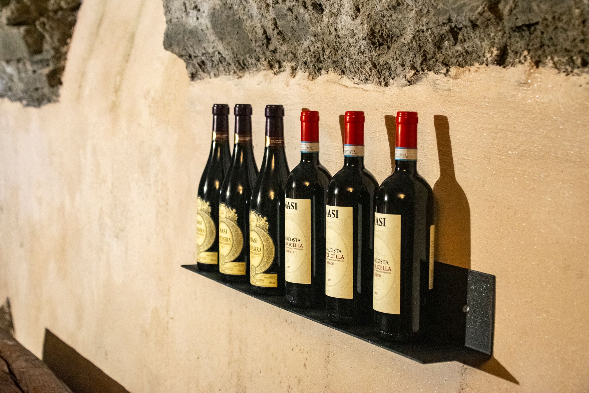 Bottiglie di vino sono allineate su uno scaffale su una parete.