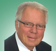 The man is wearing glasses and a suit and tie.