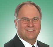 A man in a suit and tie is smiling for the camera.