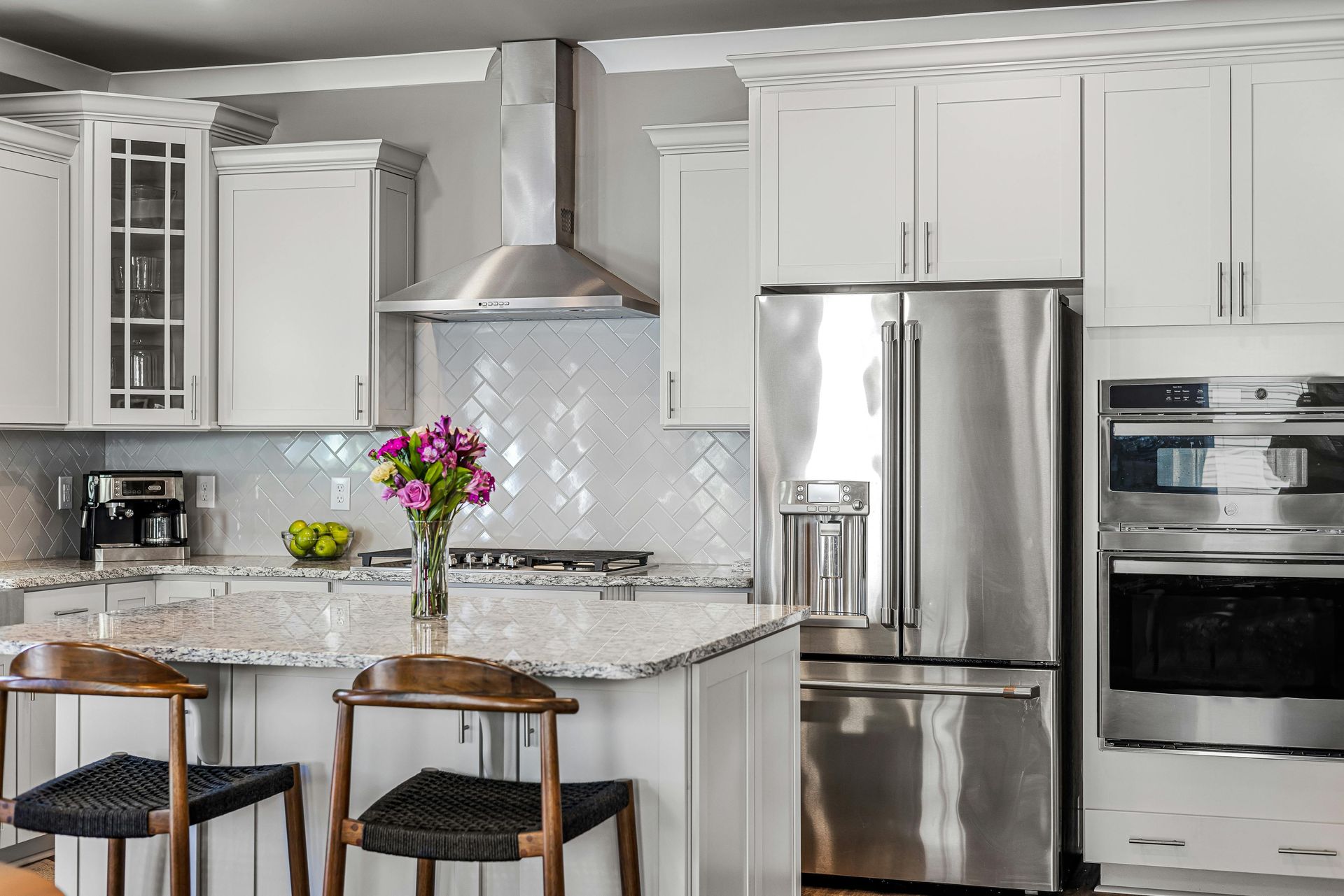 A kitchen with white cabinets and stainless steel appliances.