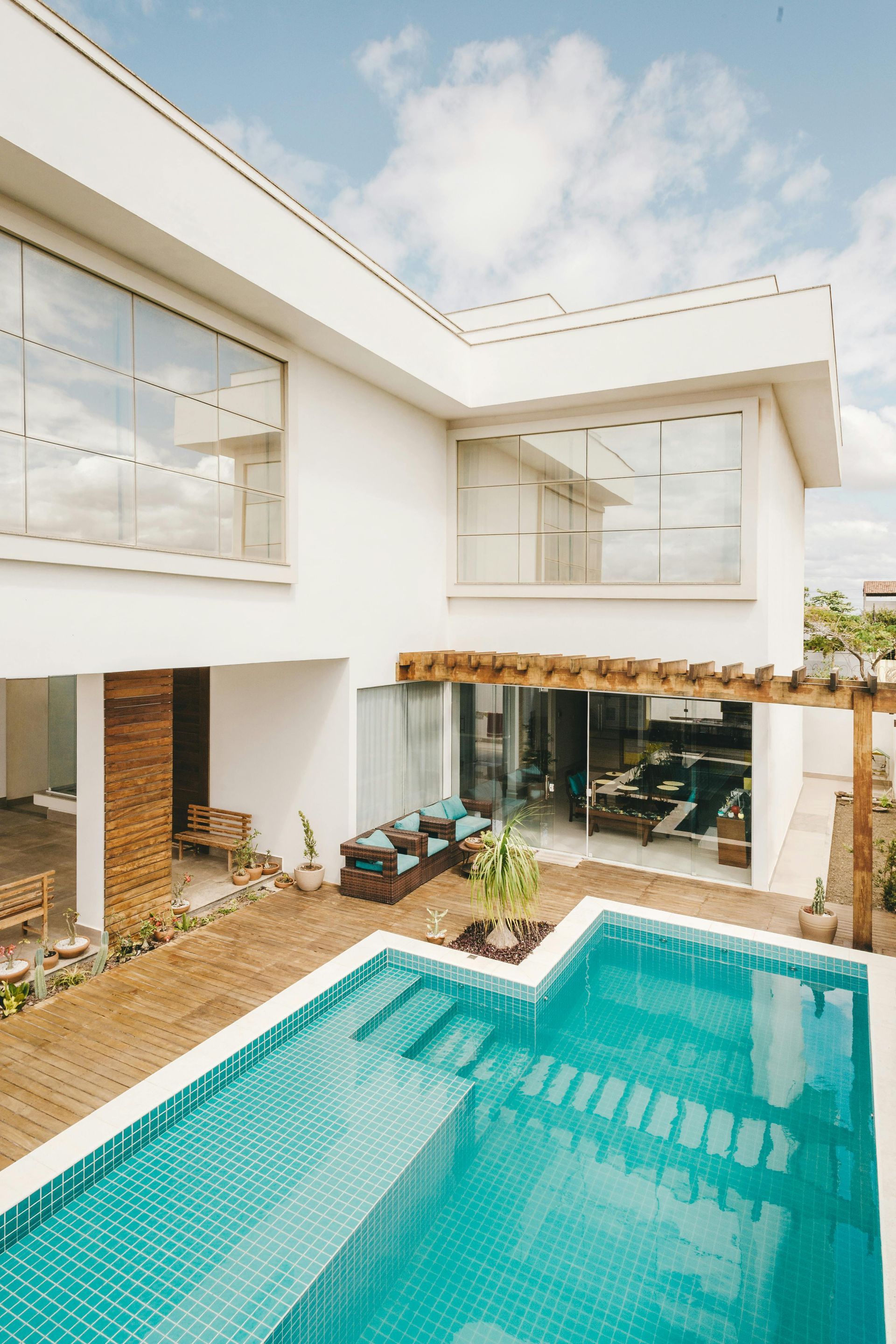 A large white house with a swimming pool in front of it.