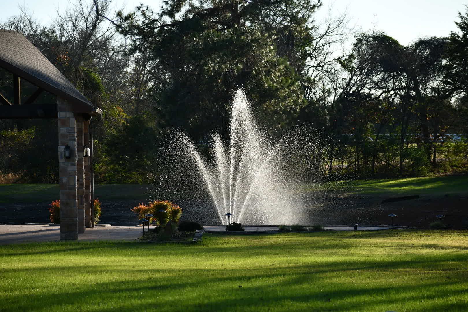 A fountain is spraying water into a lake at night.