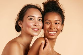 Two women are posing for a picture together and smiling.