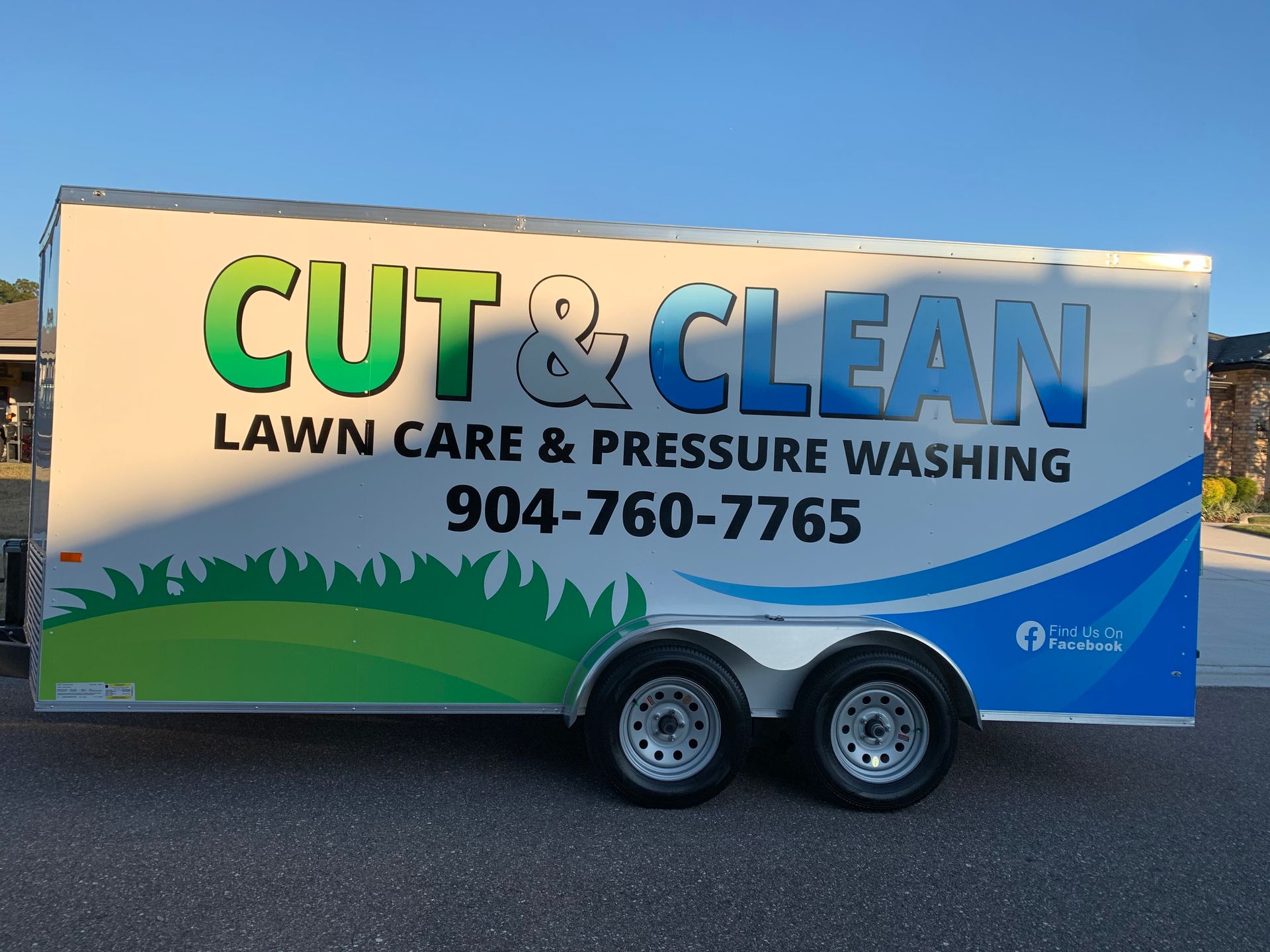 Man in black shirt and tan pants leaning against a ledge, smiling.