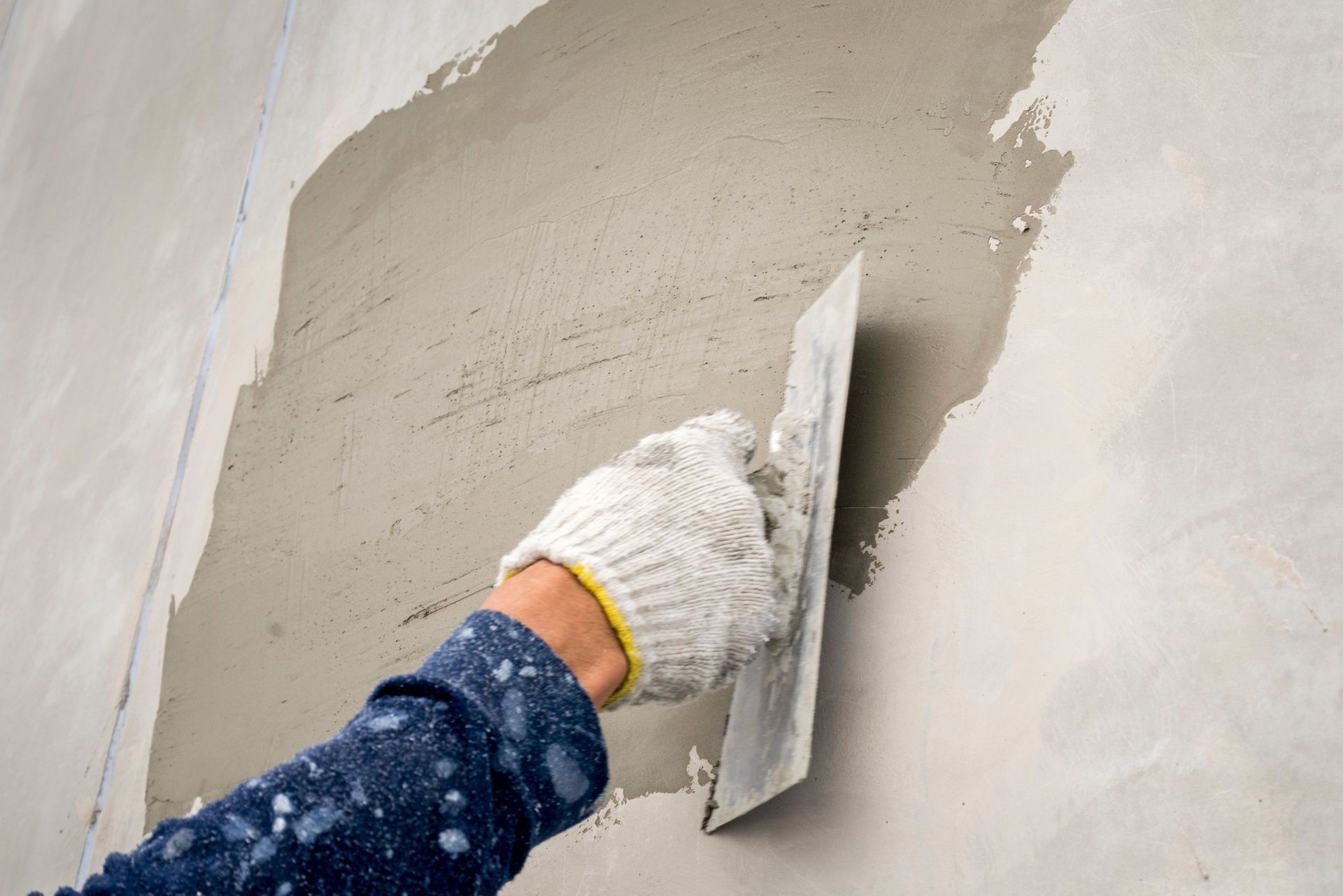 Closeup Hand Construction Plastering Wet Cement on The Loft Wall | Taylor, MI | Cooks Plastering