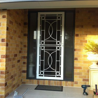 A White Security Door With Geometric Patterns — Abundance Blinds In Charmhaven, NSW
