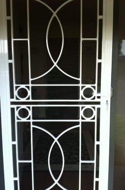 White Security Door With Geometric Metalwork — Abundance Blinds In Wyong, NSW