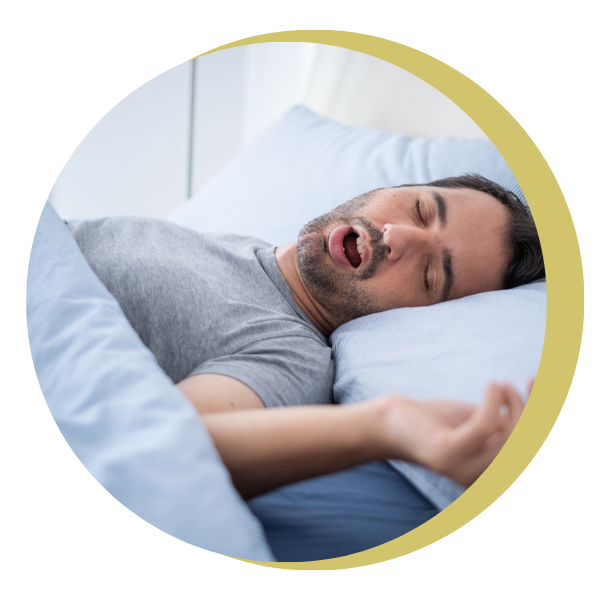A man is sleeping in a bed with his mouth open.