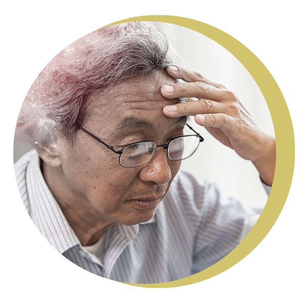 An older man wearing glasses is holding his head.