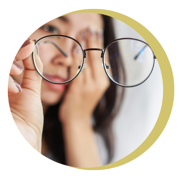 A woman is holding a pair of glasses in her hand.
