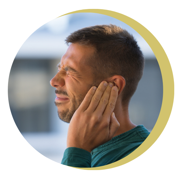 A man in a green shirt is holding his ear in pain