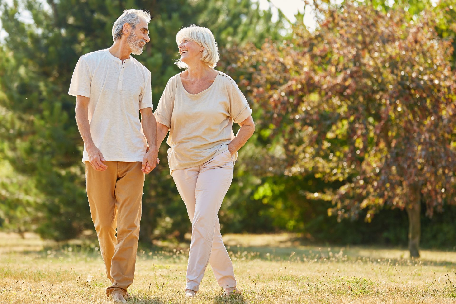 Person showing phone with urn image; another person looks on. Sunlight streams in.