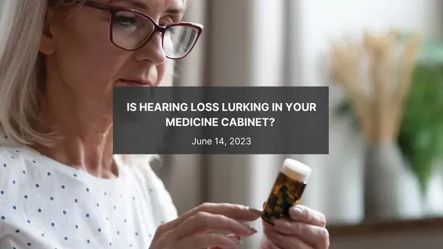 An older woman wearing glasses is holding a bottle of pills.