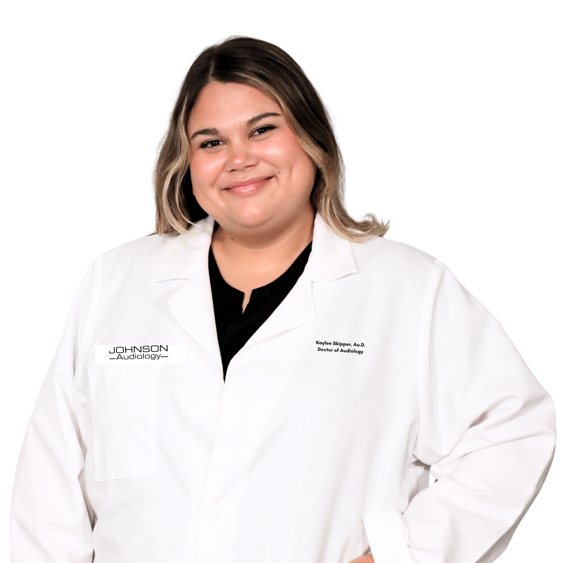 A woman in a white lab coat is smiling and holding a pair of keys.