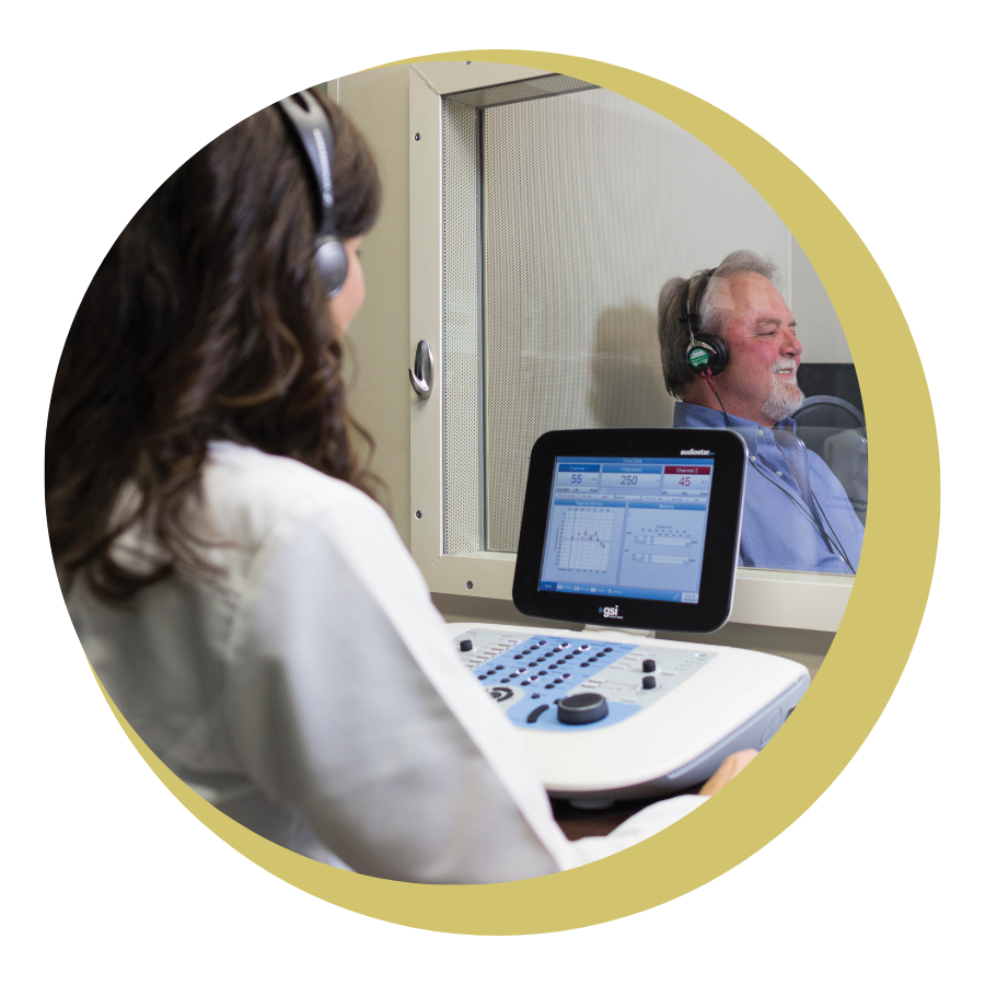 A man in a green shirt is holding his ear in pain