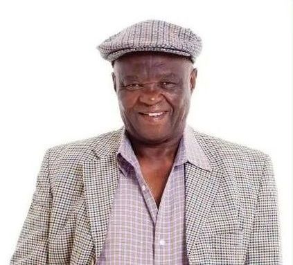 A man wearing a hat and a jacket is smiling.