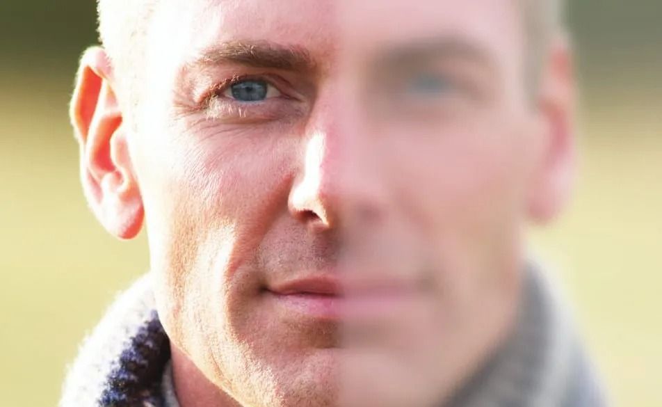 A close up of a man 's face with a blurry background.