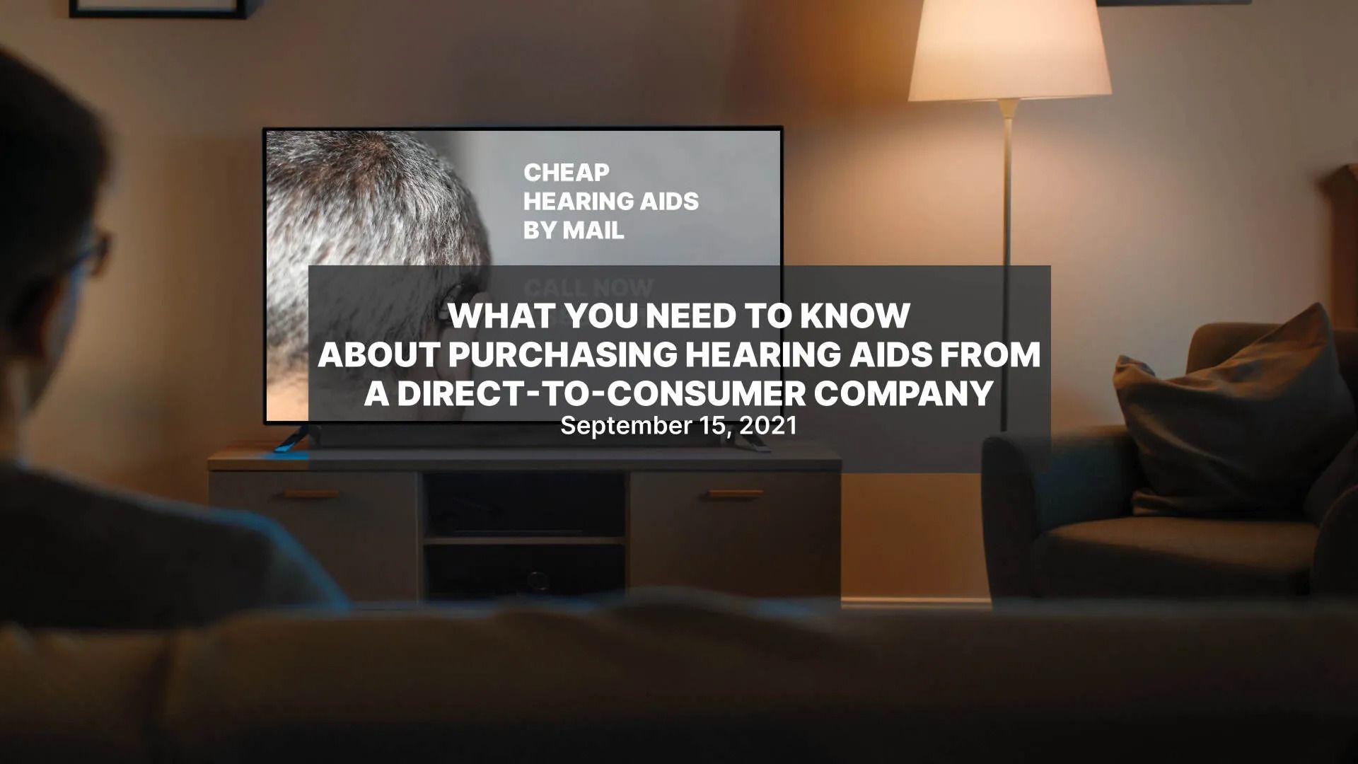 A man is sitting in front of a television in a living room.