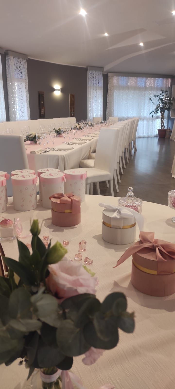 Un lungo tavolo con fiori e scatole sopra in una stanza.