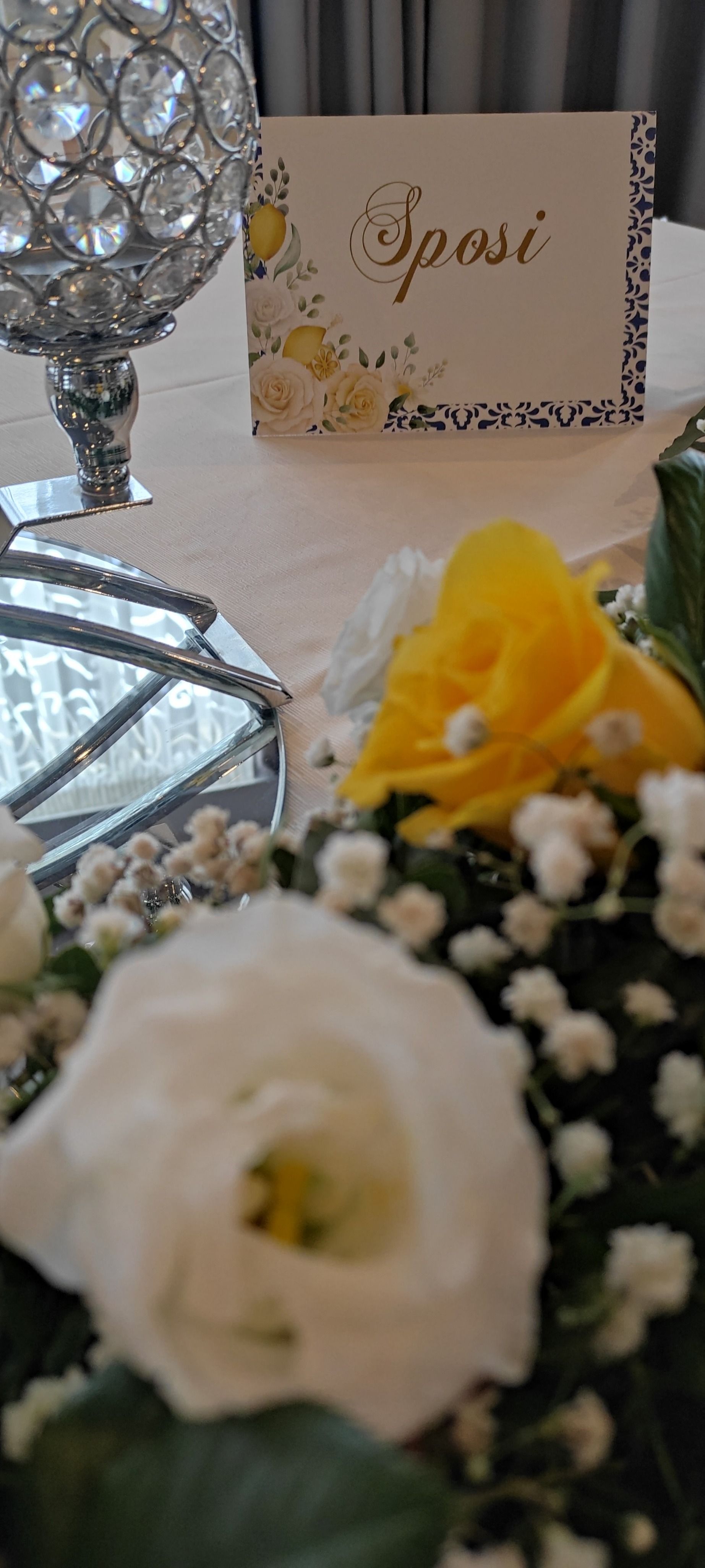 Un tavolo con dei fiori e un segnaposto sopra.