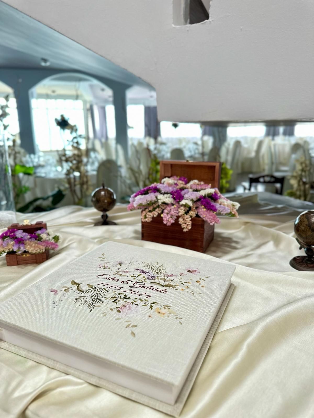 Un libro è appoggiato su un tavolo accanto a una scatola di fiori.