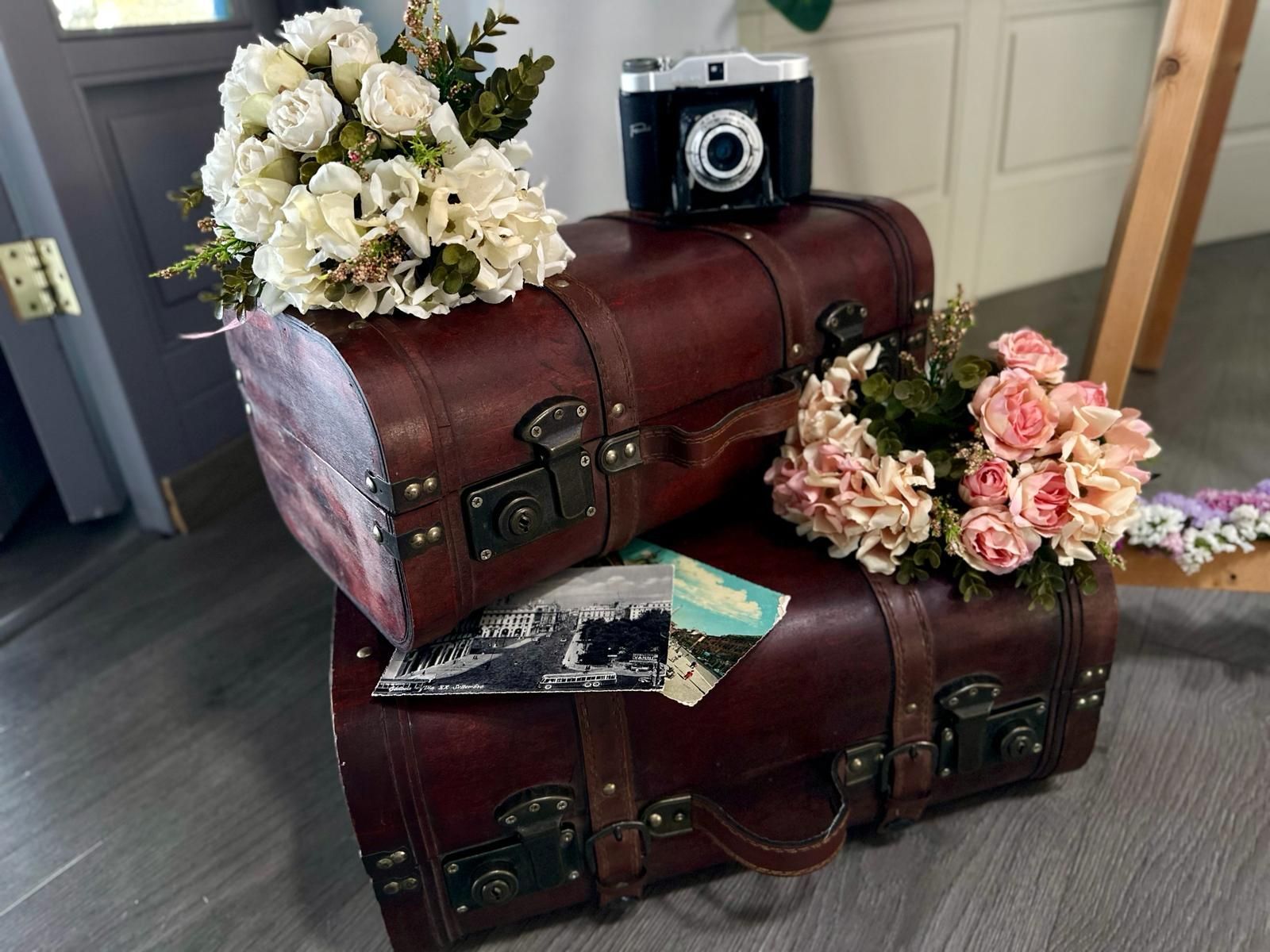 Due valigie con fiori e una macchina fotografica sopra