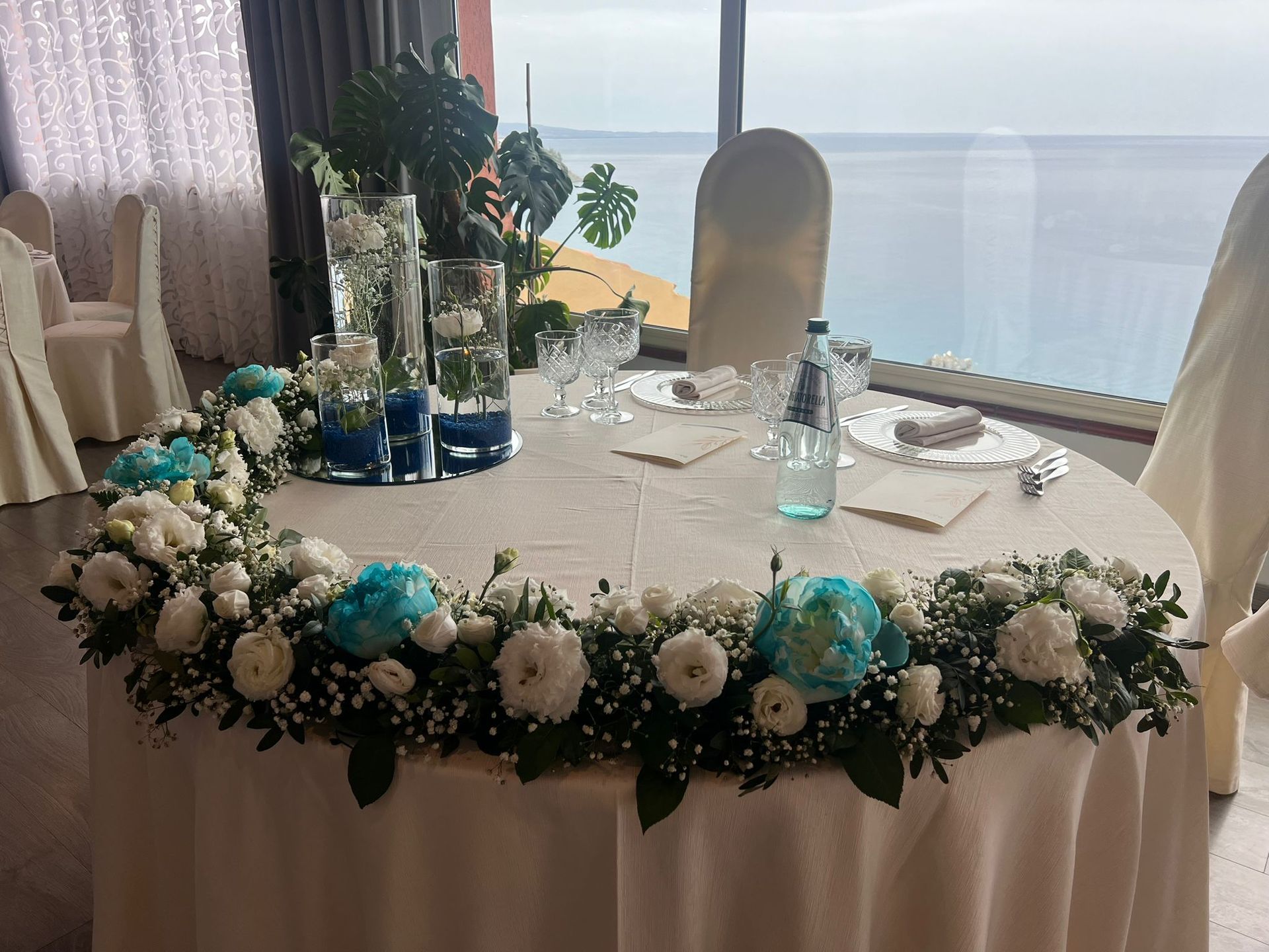 Un tavolo con dei fiori sopra e una vista sull'oceano.