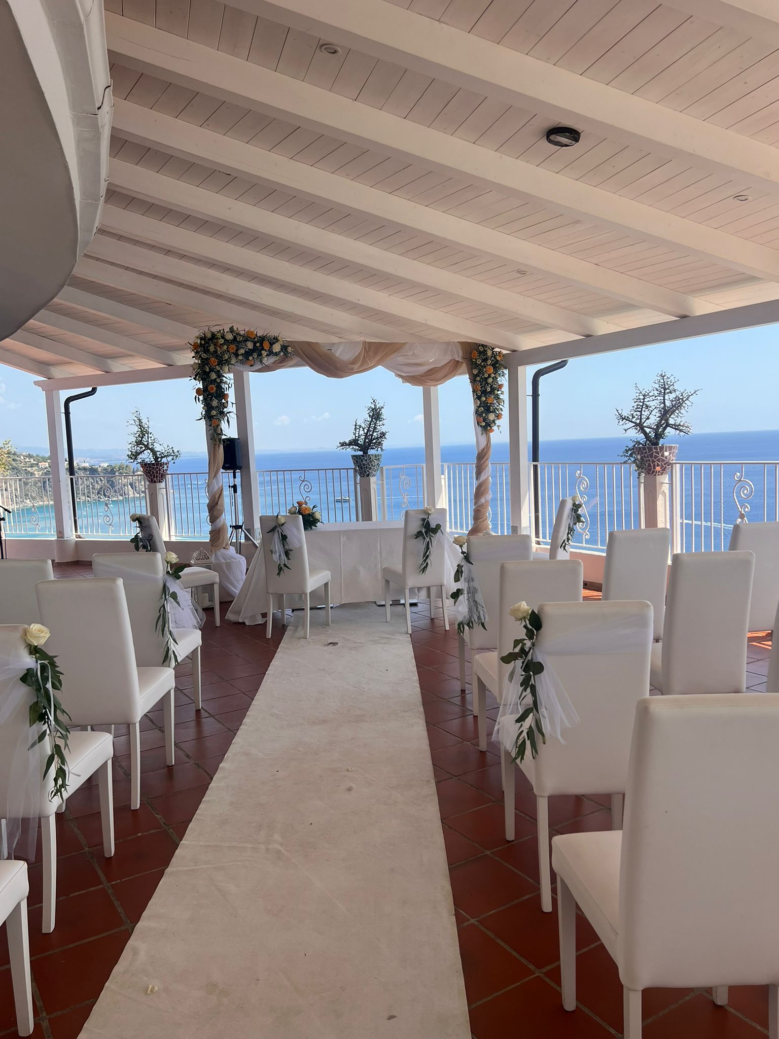 Una stanza con sedie bianche e un tappeto bianco che conduce all'oceano