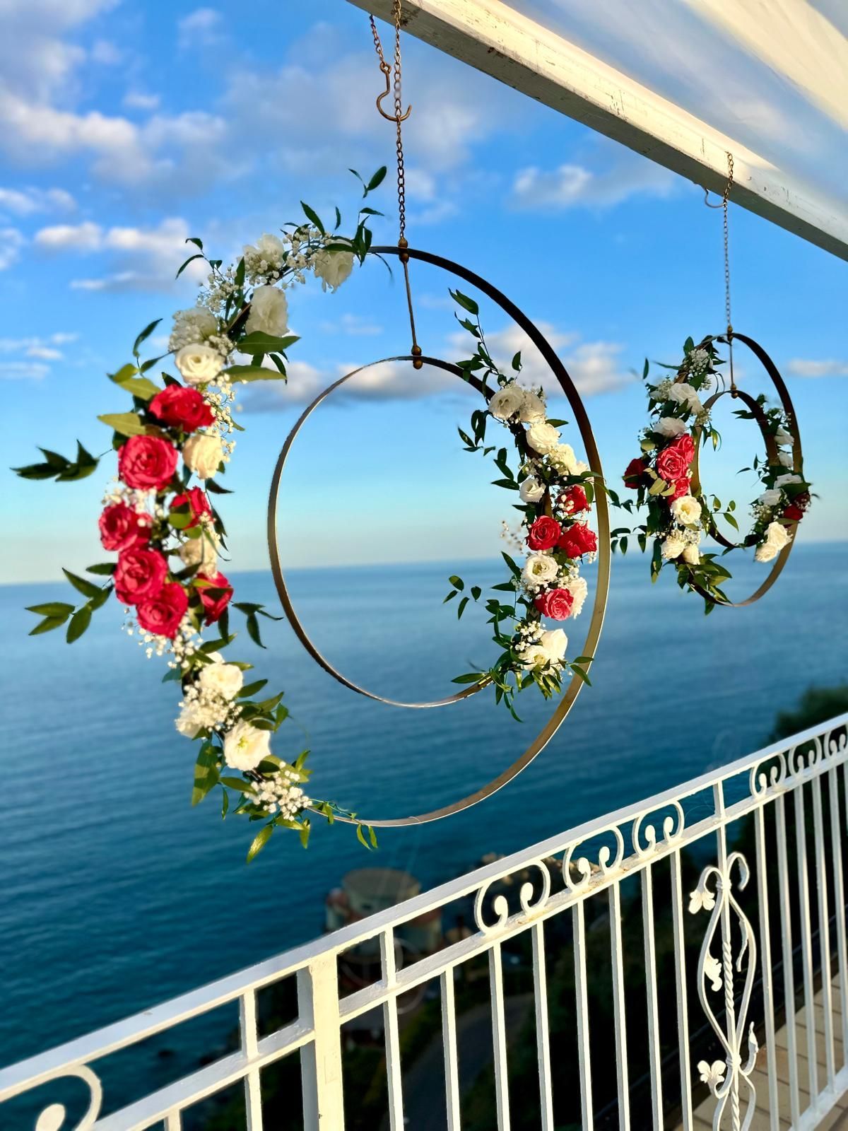 Due corone di fiori sono appese a una ringhiera che si affaccia sull'oceano.