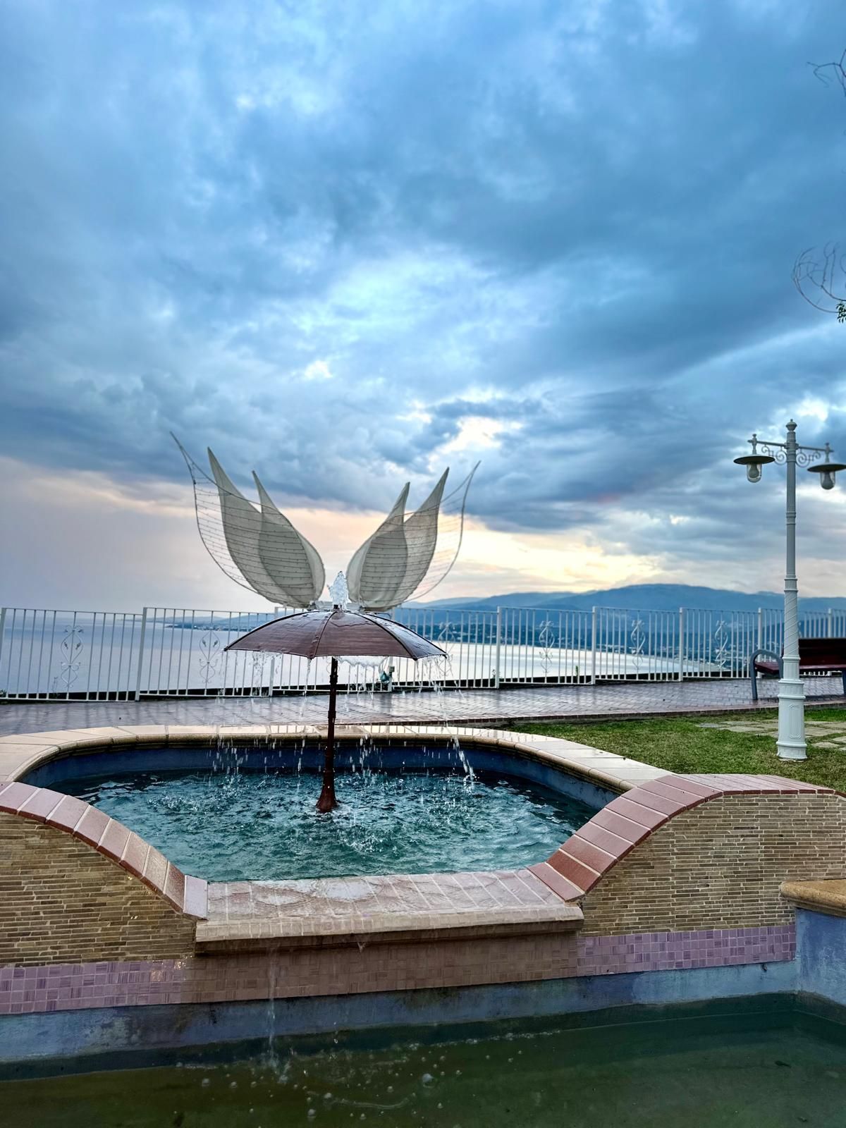 Una fontana con una statua di ali in cima