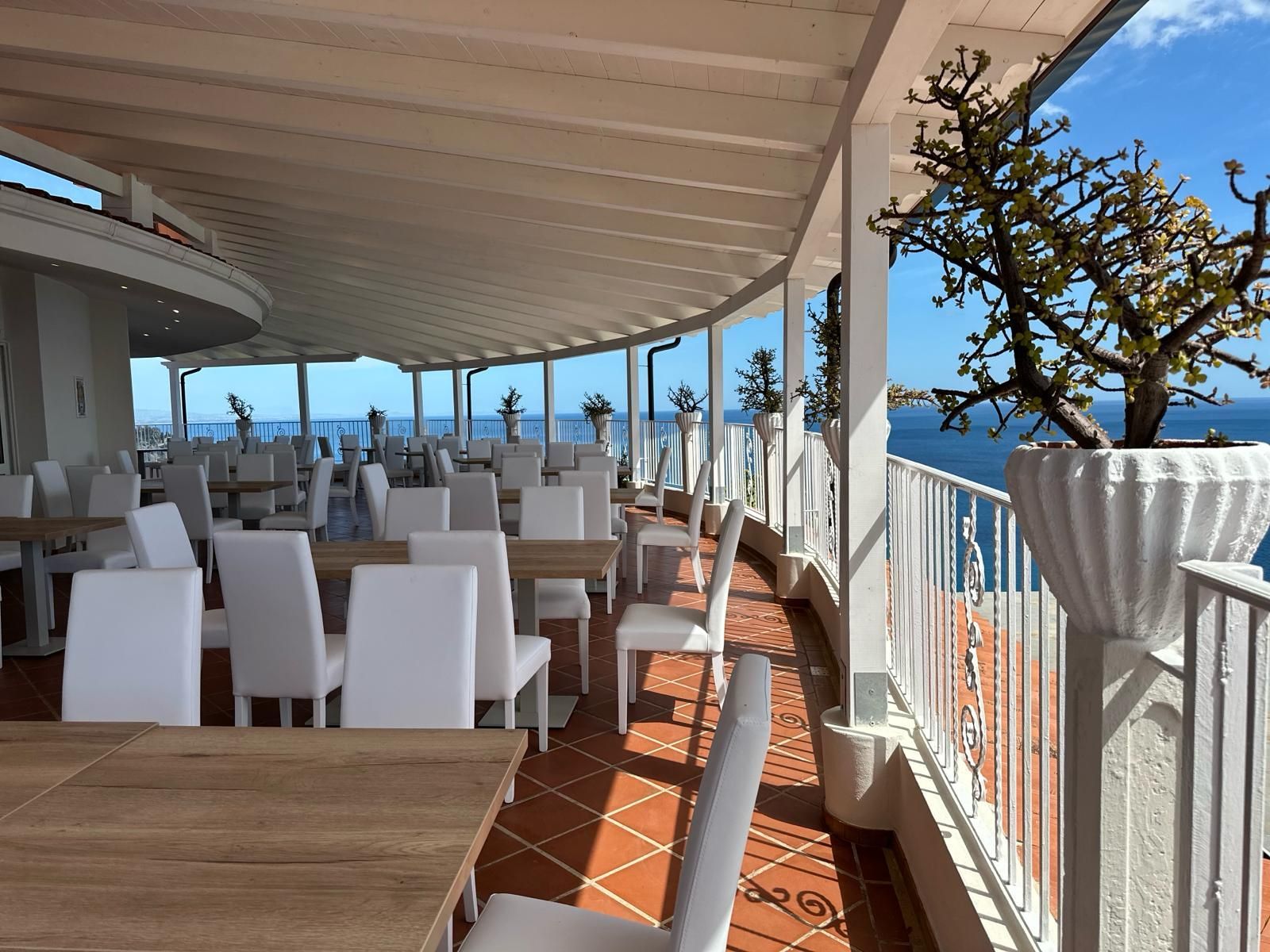 Un ristorante con tavoli e sedie con vista sull'oceano