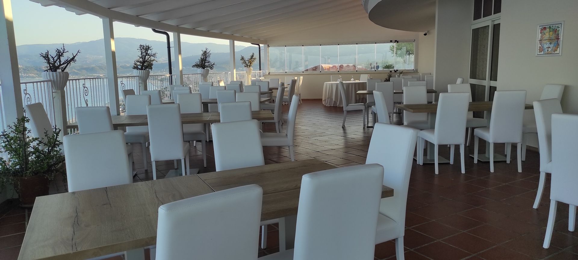 Un ristorante pieno di tavoli e sedie con vista sull'oceano