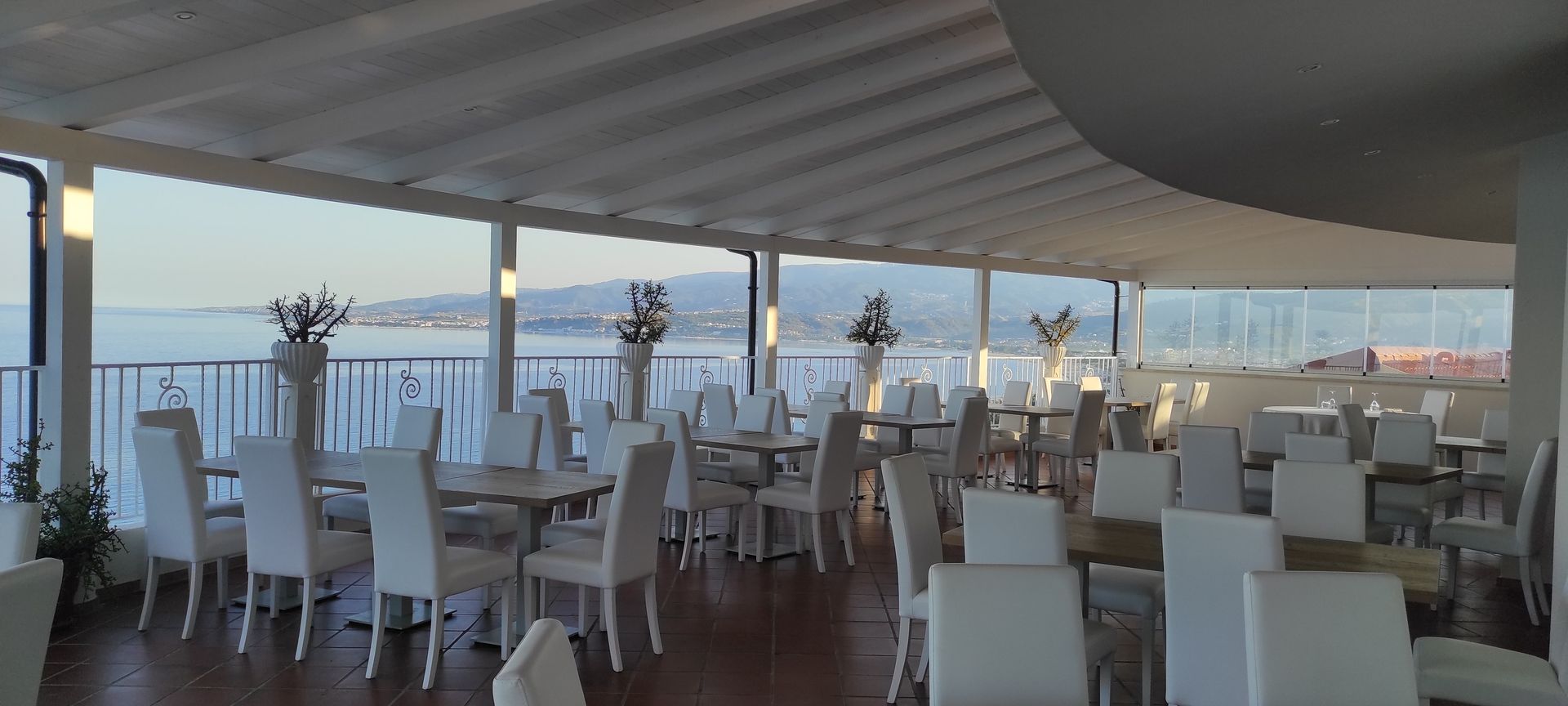 Un ristorante con tavoli e sedie con vista sull'oceano