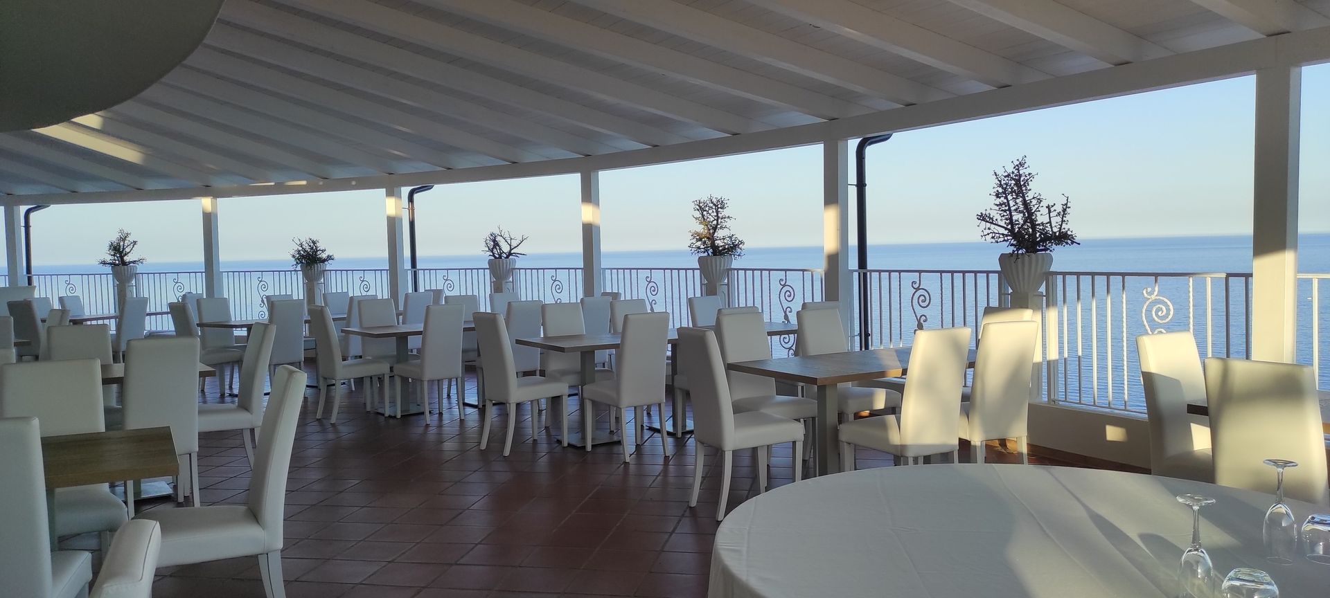 Un ristorante con tavoli e sedie con vista sull'oceano