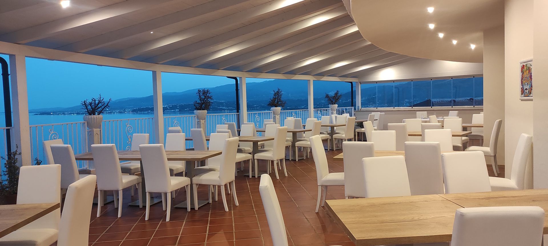 Un ristorante con tavoli e sedie e vista sull'oceano.