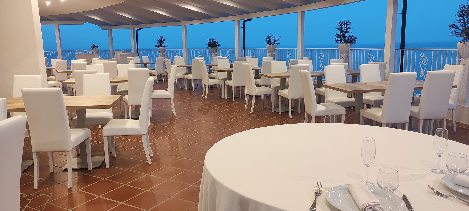 Una grande sala da pranzo con tavoli e sedie e vista sull'oceano.