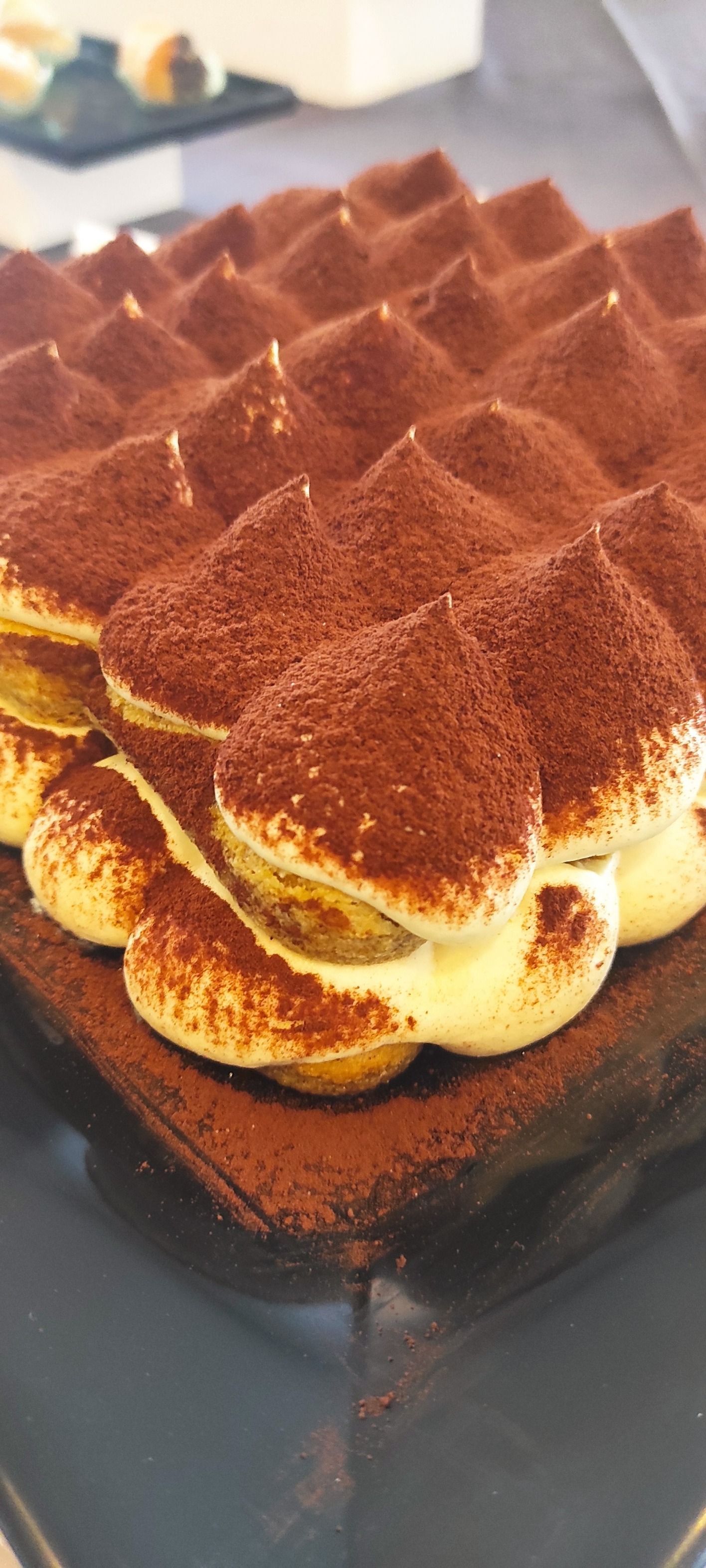 Un primo piano di una torta tiramisù su un tavolo.