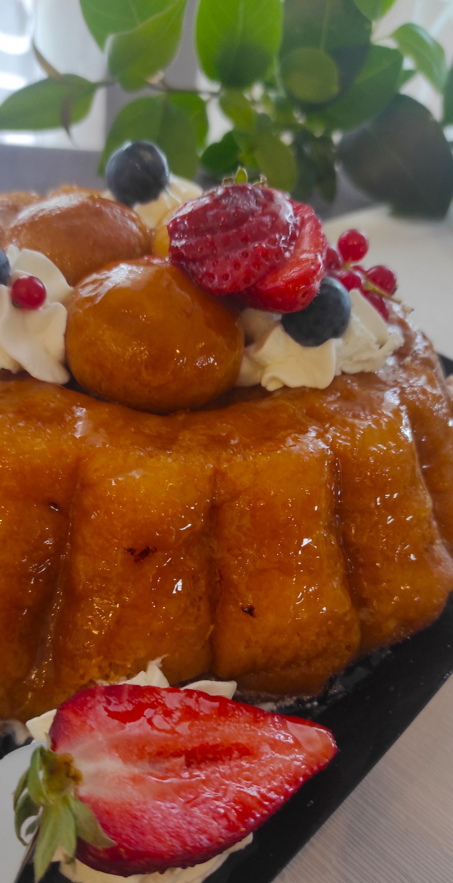 Un primo piano di un dessert con fragole e mirtilli sopra.