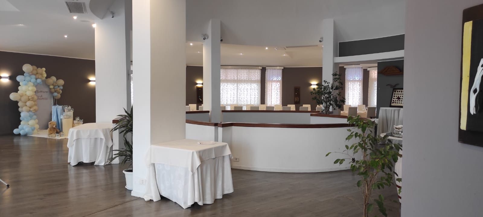 Una grande stanza con tavoli e un bancone al centro.