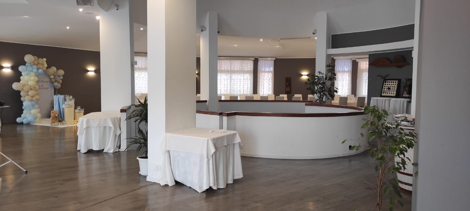 Una grande stanza con tavoli e un bancone al centro.