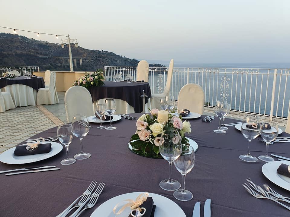 Un tavolo con piatti, bicchieri da vino e fiori sopra