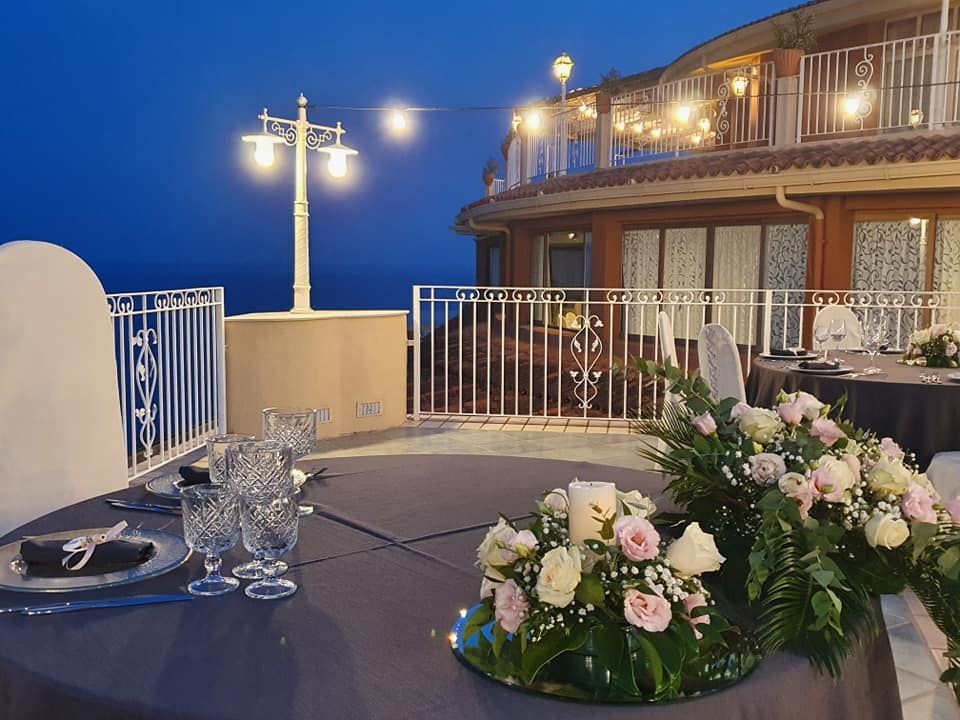 Un tavolo con piatti, bicchieri e fiori sopra.