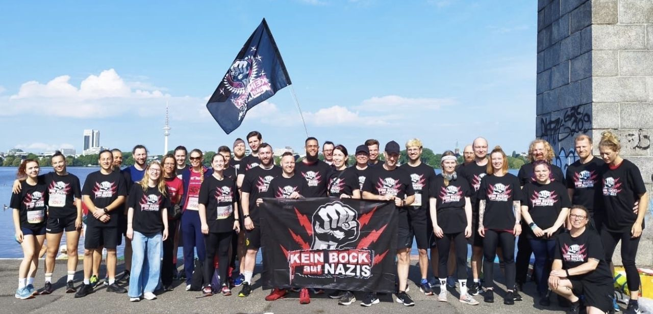 Eine Gruppe von Menschen in schwarzen Hemden mit einem Banner mit der Aufschrift „Kein Bock auf Nazis“