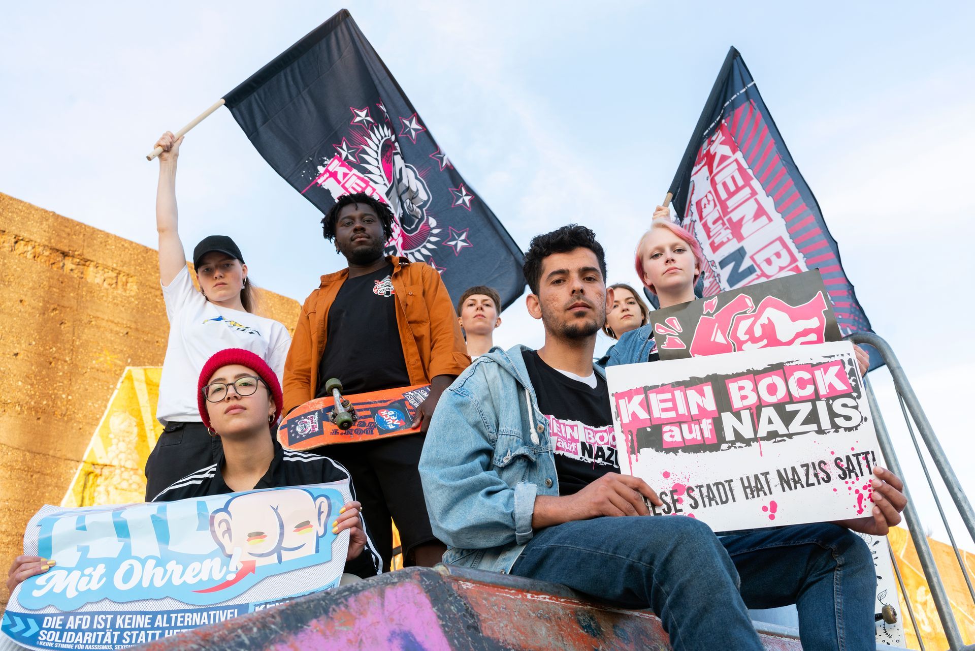 Eine Gruppe von Menschen protestiert mit Schildern und Fahnen. Auf den Fahnen und Schildern steht: „Kein Bock auf Nazis“.