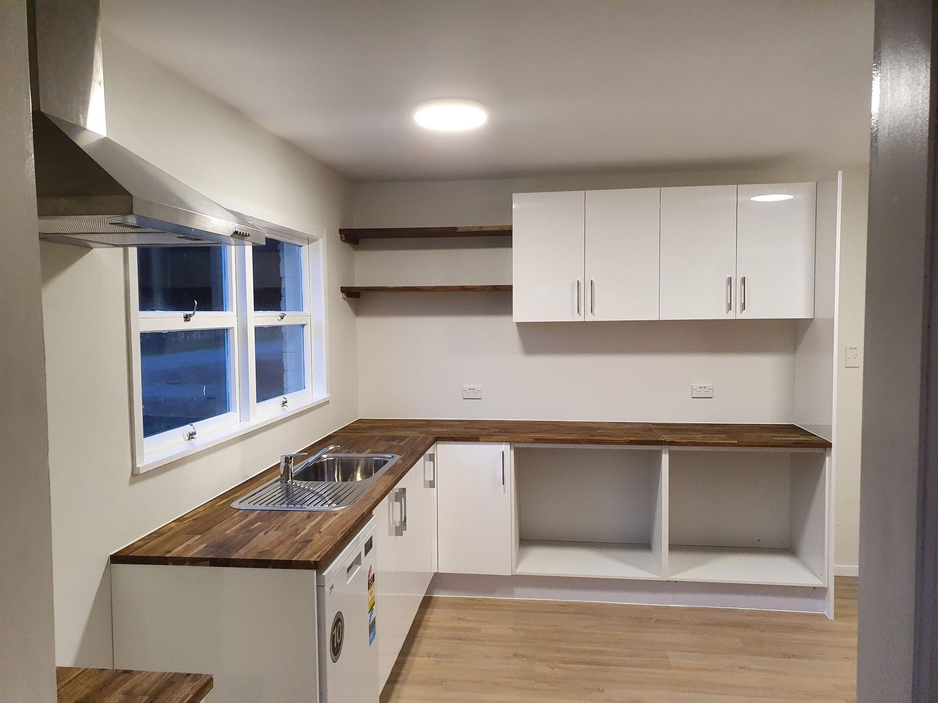 A kitchen with white cabinets and wooden counter tops