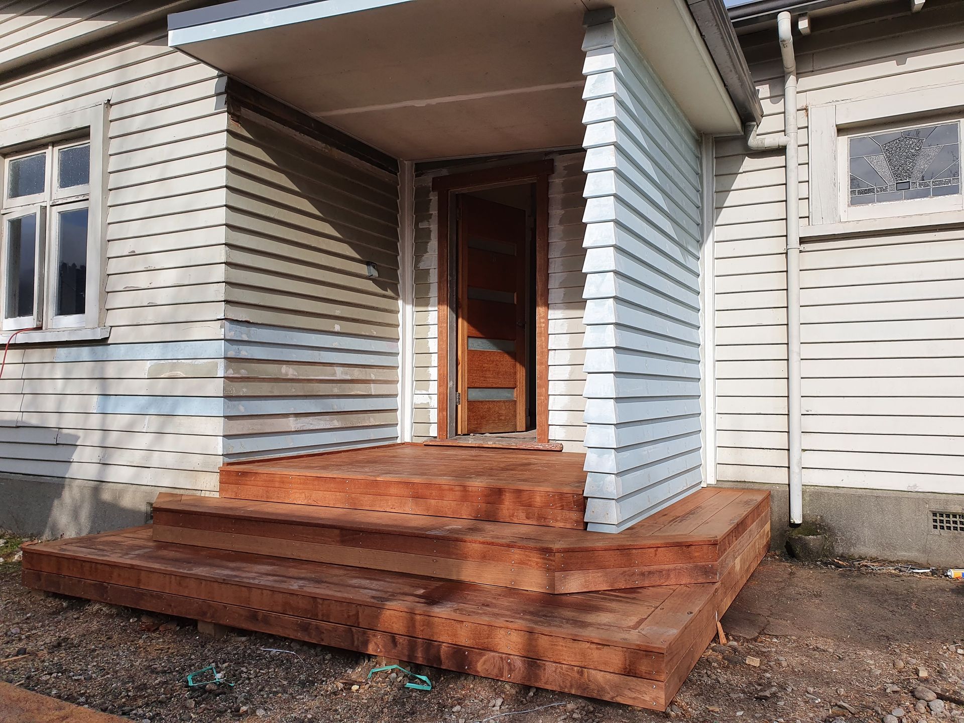 A white house with a wooden porch and stairs