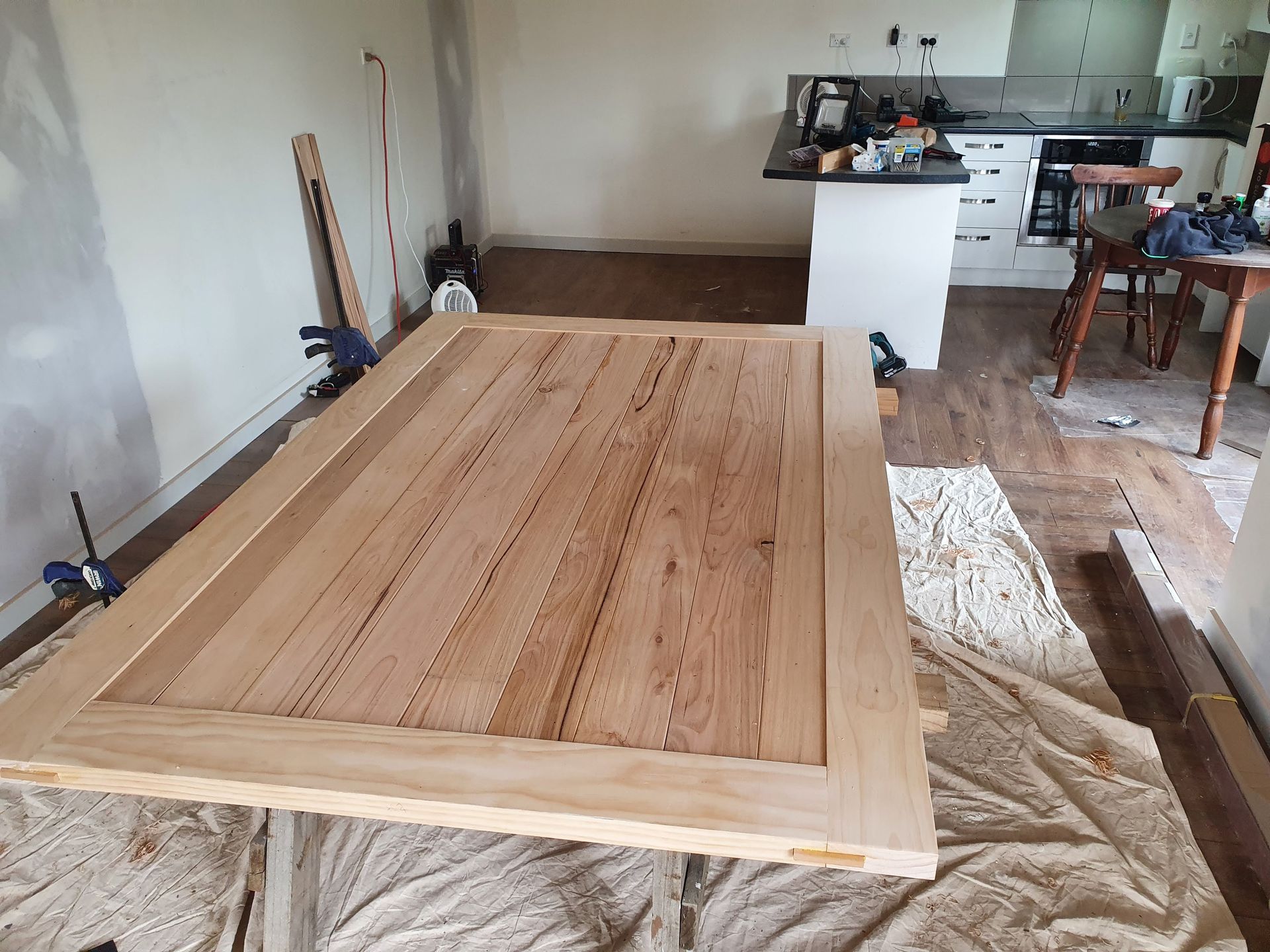 A wooden table is being built in a kitchen.
